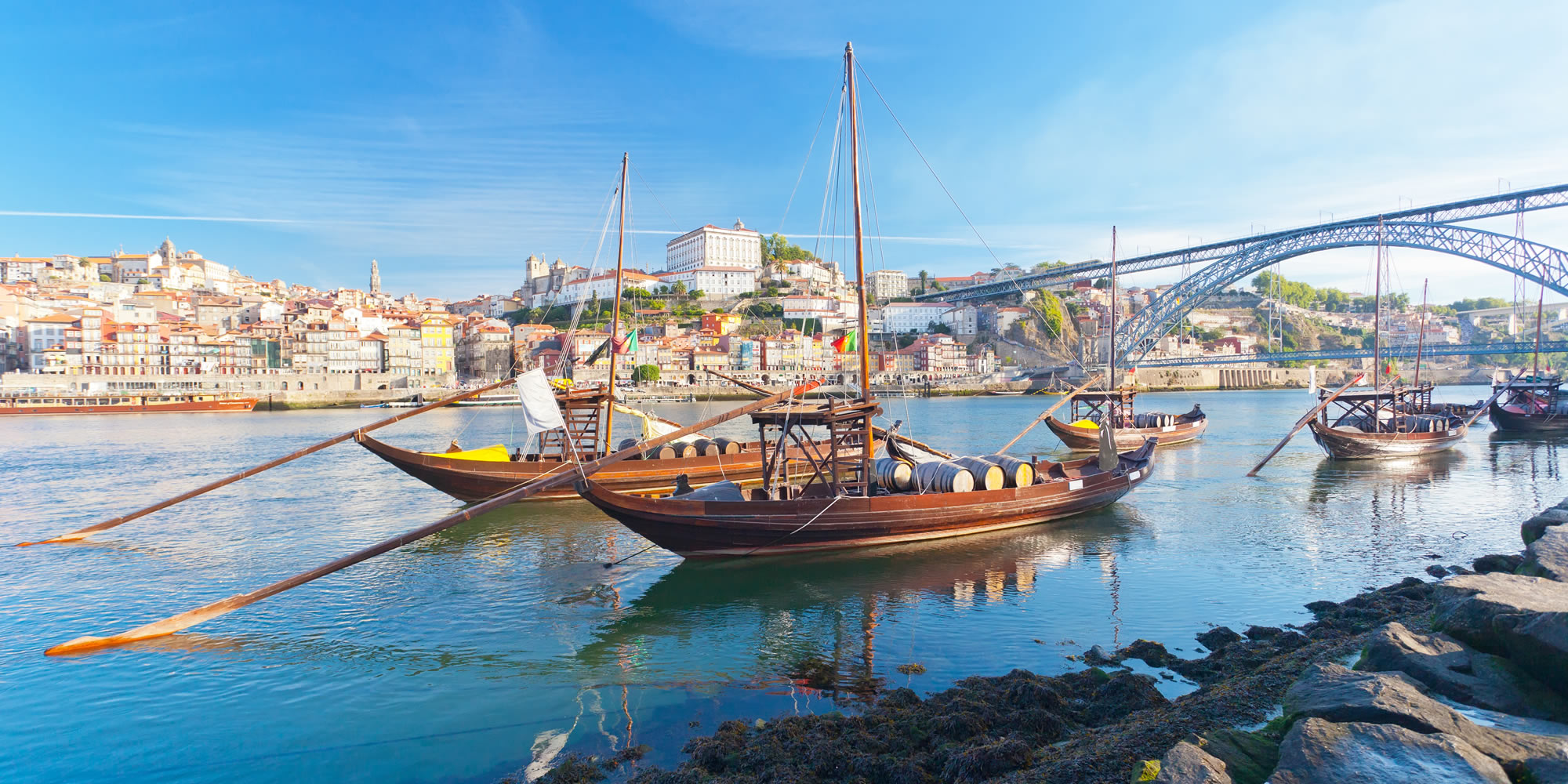 Traditional rabelo boats on the Douro River with Porto Ribeira district and Luís I Bridge